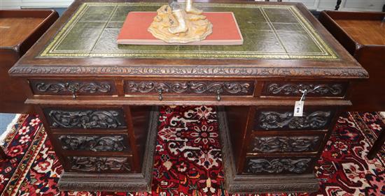 A late Victorian carved oak pedestal desk W.136cm